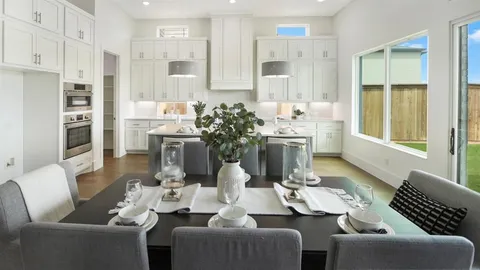 a living room with furniture potted plant and kitchen view
