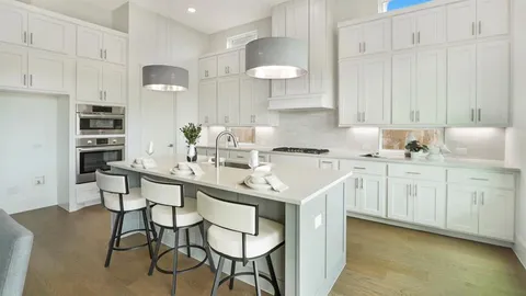 a kitchen with stainless steel appliances a sink a stove a refrigerator and cabinets