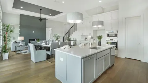 a kitchen with a sink a counter top space and living room view