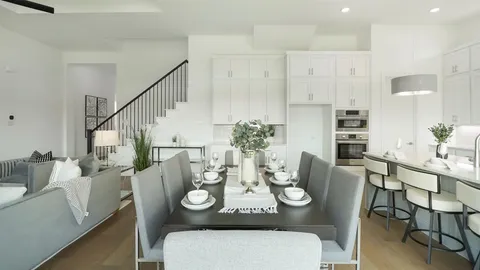 a view of a dining room with furniture a potted plant and wooden floor