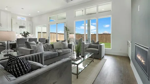 a living room with furniture floor to ceiling window and a flat screen tv