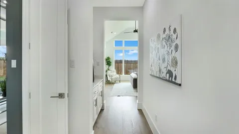 a view of a hallway with wooden floor and windows