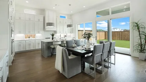 a view of a dining room and livingroom with furniture wooden floor a chandelier