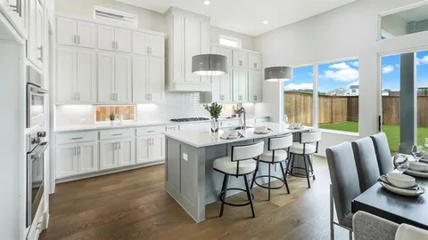 a kitchen with a dining table chairs and white cabinets