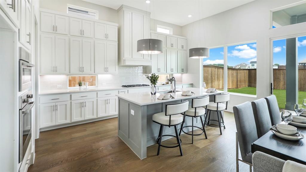 165 Lantern Ridge Drive Aledo, TX 76008 - Photo 9 of 38 a kitchen with a dining table chairs and white cabinets