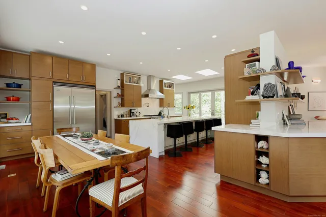 a kitchen with a table chairs refrigerator and cabinets