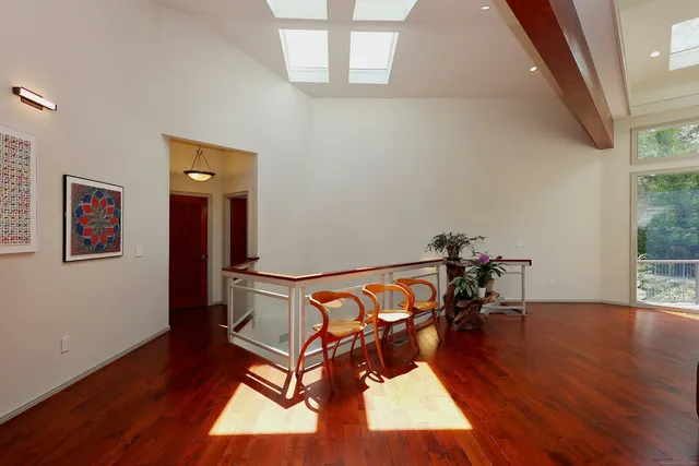 a view of a room with wooden floor table and chairs