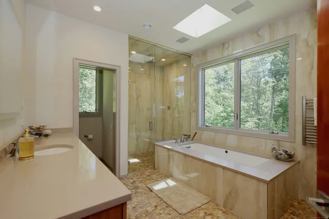 a bathroom with a tub sink and mirror