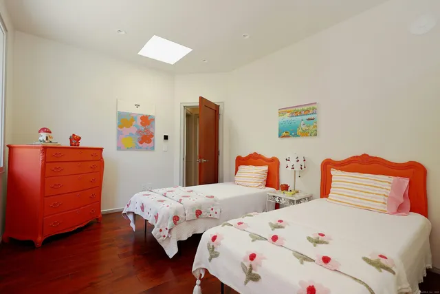 a bedroom with two beds and painting on the wall