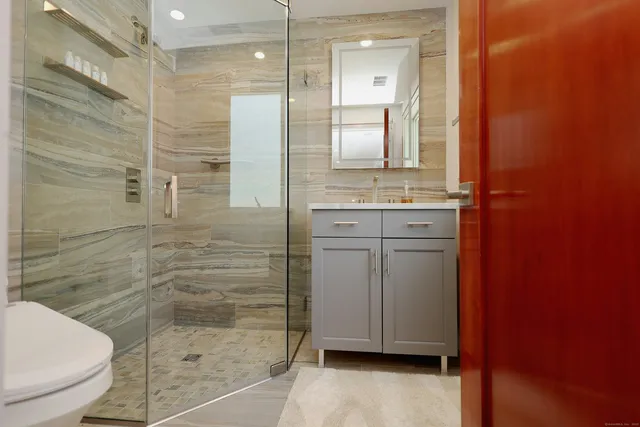 a bathroom with a granite countertop sink toilet and shower