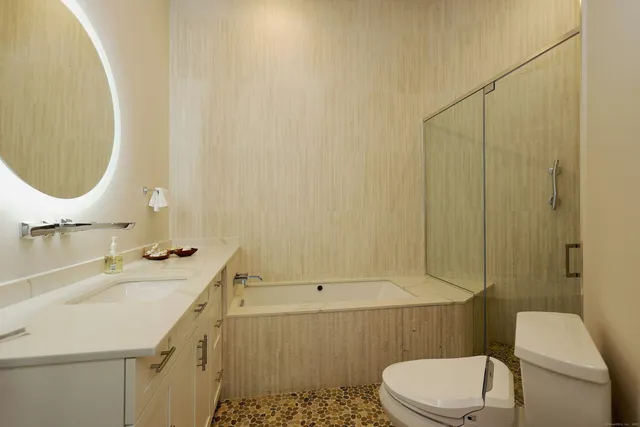 a bathroom with a sink a toilet and shower