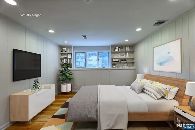 a bedroom with a large bed and a flat screen tv