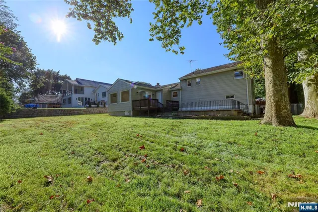 a view of a house with a big yard and large trees
