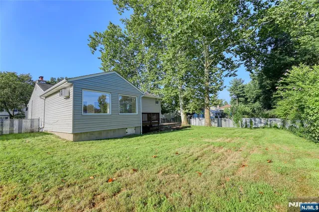 a view of a yard in front of a house with large trees