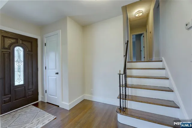 a view of a hallway with wooden floor and entryway