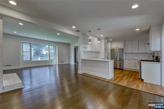 a open kitchen with white cabinets and refrigerator