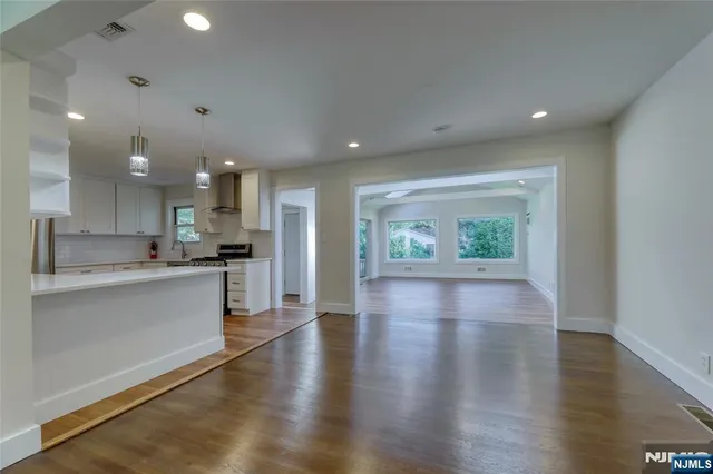 a view of kitchen with kitchen island wooden floors wooden floor and refrigerator