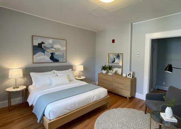 a bedroom with a bed and wooden floor