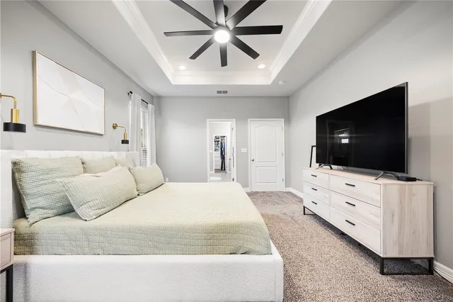 a spacious bedroom with a bed and a flat screen tv