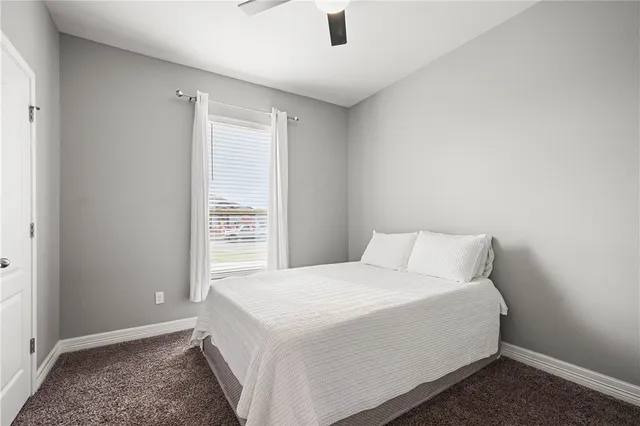a bed sitting in a bedroom next to a window