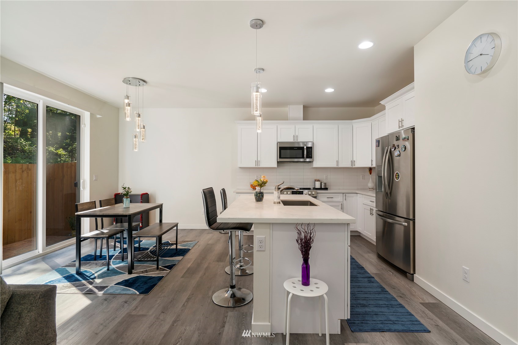 19512 Damson Road, Unit A Lynnwood, WA 98036 - Photo 8 of 37 a kitchen with stainless steel appliances a dining table chairs refrigerator and sink