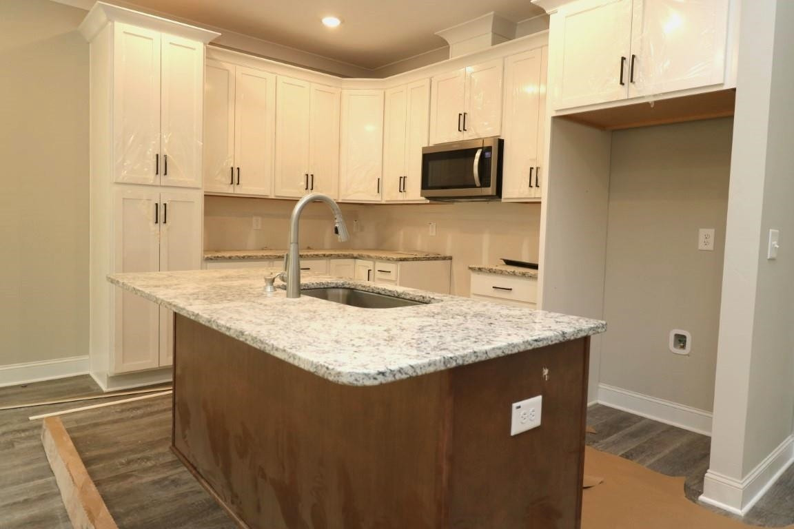 a kitchen with stainless steel appliances granite countertop a sink a microwave and cabinets