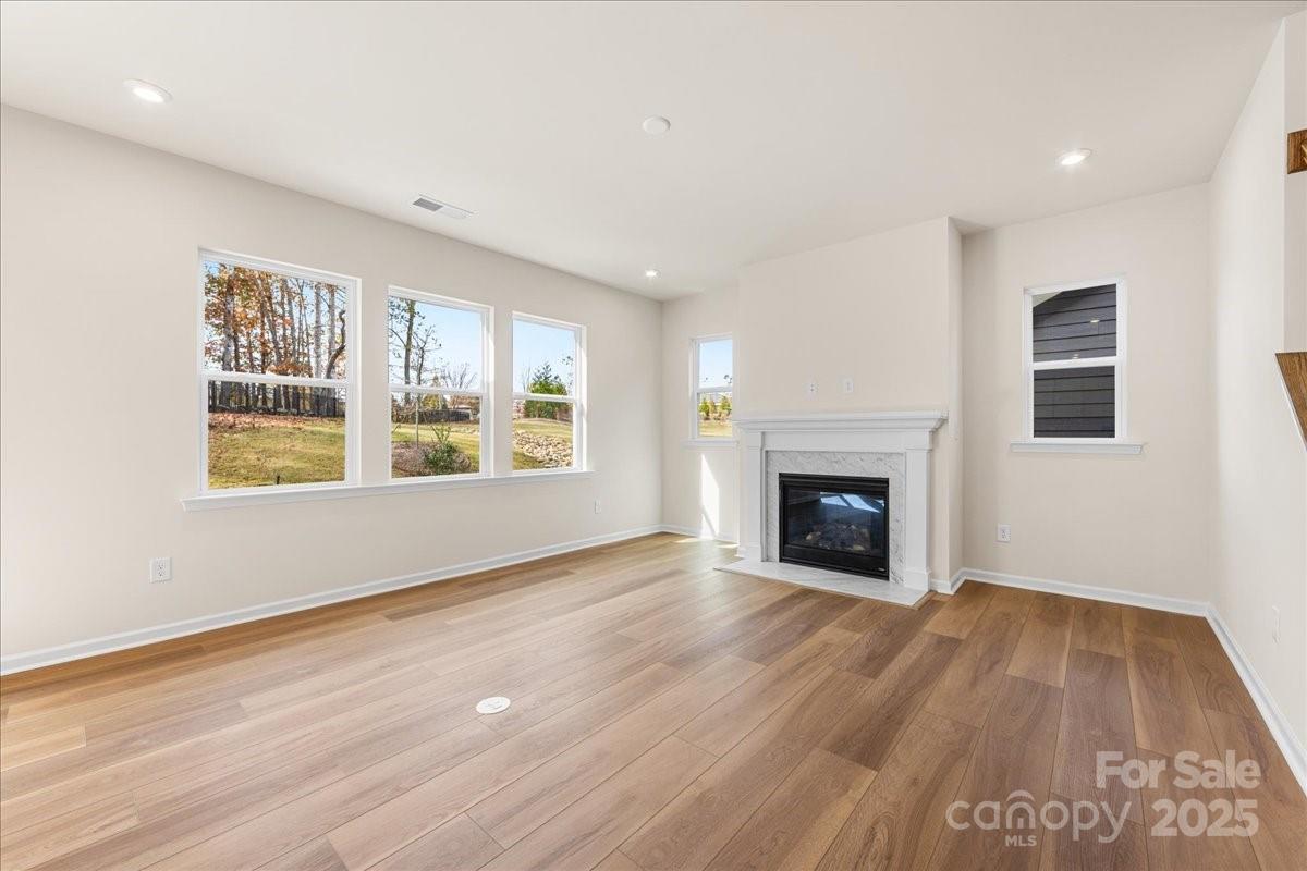 8233 Franklin Trl Street Mint Hill, NC 28227 - Photo 8 of 17 a view of an empty room with wooden floor fireplace and a window