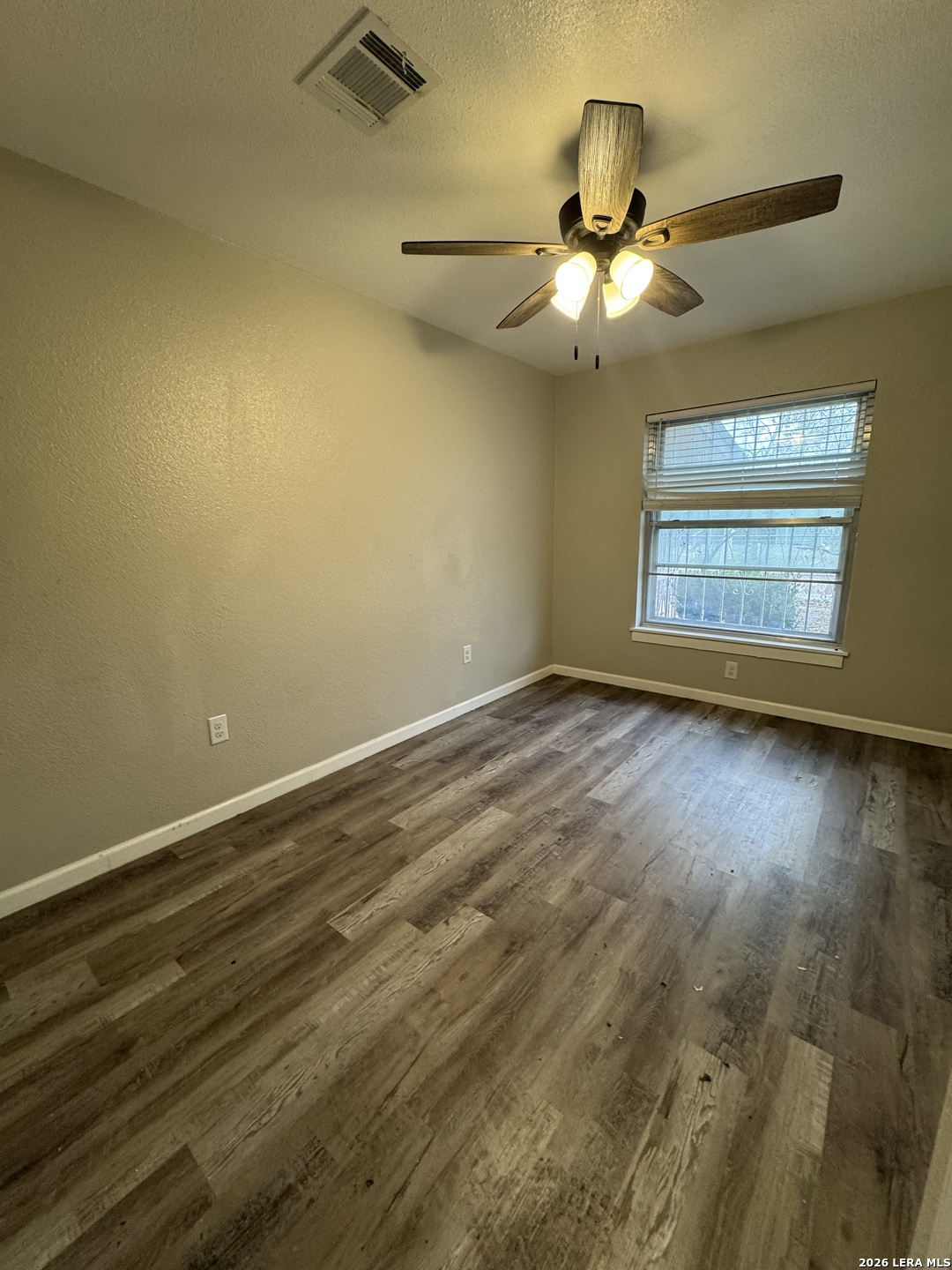 1240 Rice Road San Antonio, TX 78220 - Photo 14 of 45 an empty room with wooden floor fan and windows
