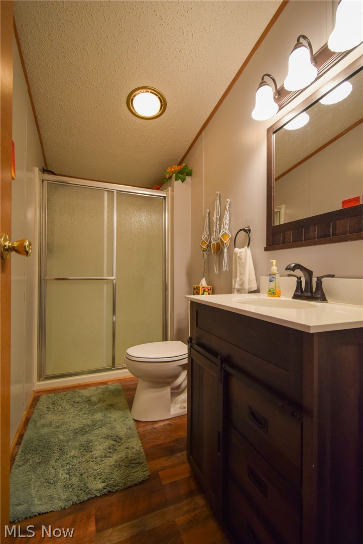 26933 Marina Road Freeport, OH 43973 - Photo 11 of 18 Bathroom featuring wood-type flooring, a textured ceiling, vanity, and toilet