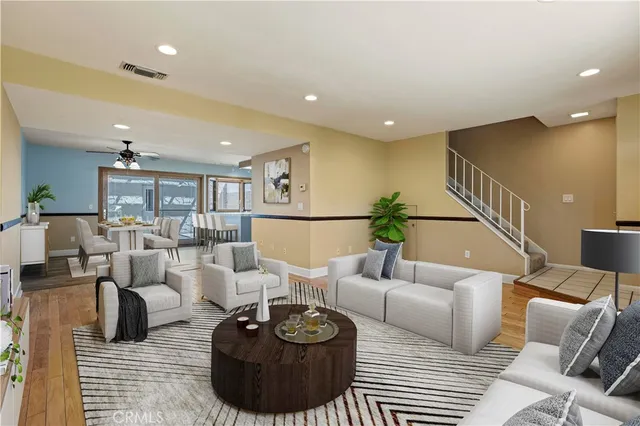 a living room with furniture and a wooden floor