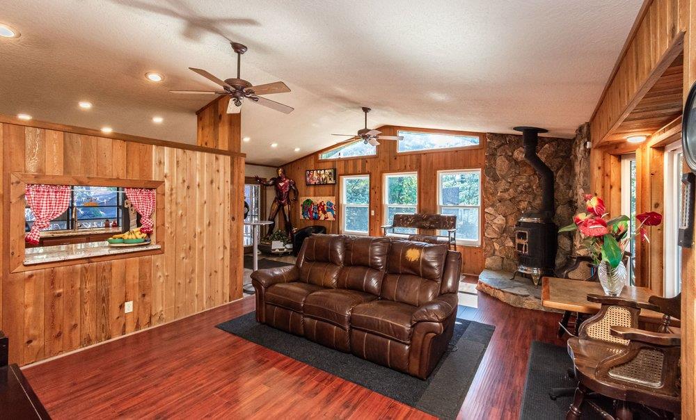 23870 Tokayana Way Colfax, CA 95713 - Photo 32 of 93 a living room with furniture a flat screen tv and a floor to ceiling window