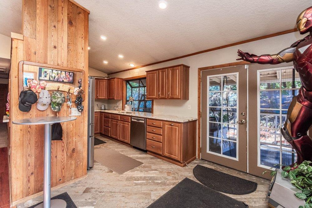 23870 Tokayana Way Colfax, CA 95713 - Photo 34 of 93 a kitchen with stainless steel appliances kitchen island granite countertop a refrigerator and wooden cabinets