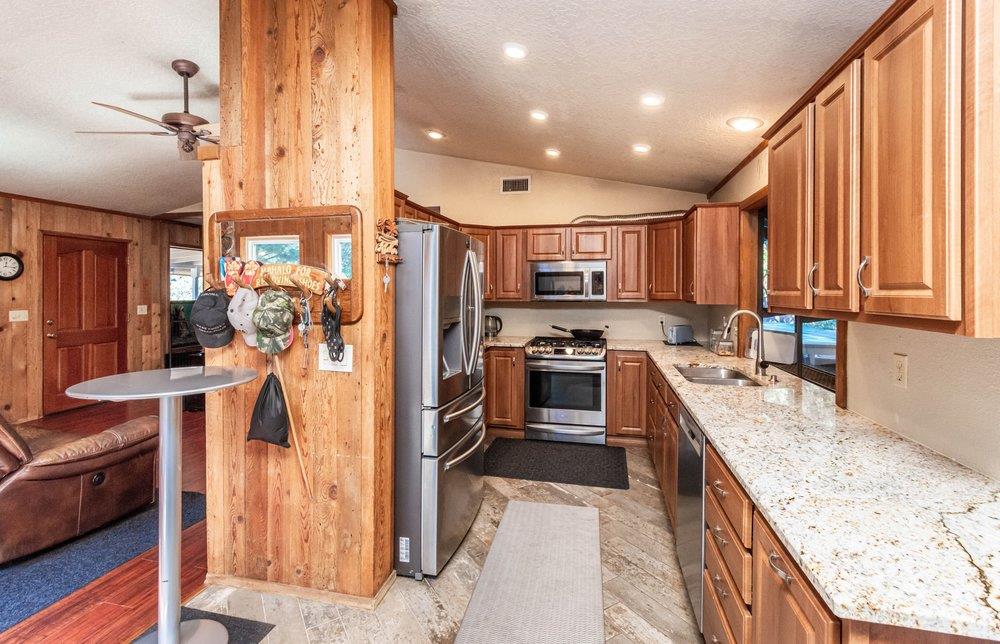 23870 Tokayana Way Colfax, CA 95713 - Photo 37 of 93 a kitchen with a refrigerator a stove top oven a sink dishwasher and wooden cabinets