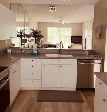 a kitchen with white cabinets and sink