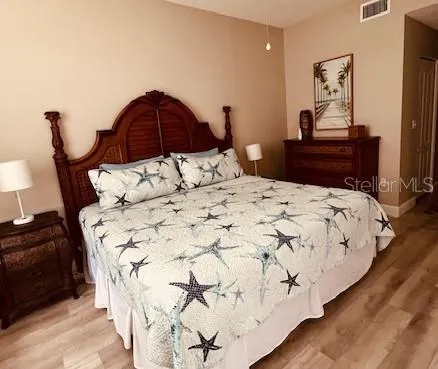 a bedroom with a bed and a mirror on dresser