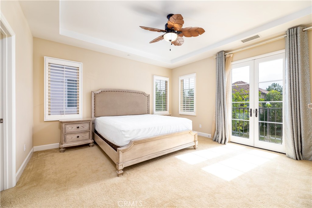 71 Thornapple Irvine, CA 92620 - Photo 13 of 33 a spacious bedroom with a large bed and a chandelier fan