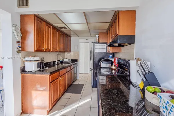 a kitchen with stainless steel appliances granite countertop a stove a sink and a refrigerator