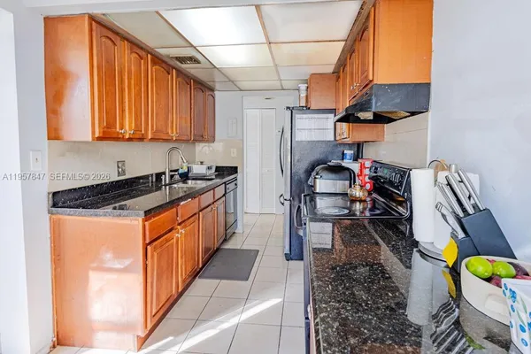 a kitchen with stainless steel appliances granite countertop a sink a stove and a refrigerator