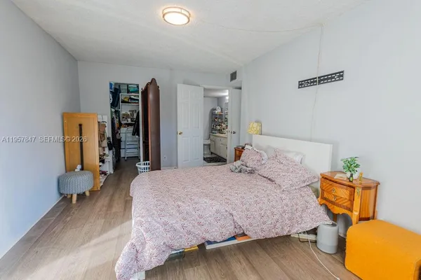 a bedroom with bed and wooden floor