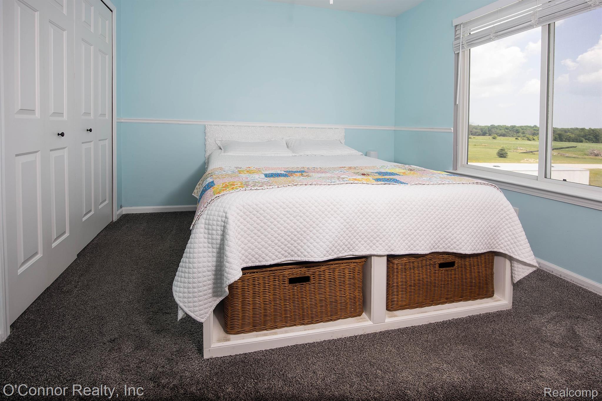 6870 Wildcat Road Jeddo, MI 48032 - Photo 18 of 44 Carpeted room with a large window, bi-fold closet doors, and light blue walls with white trim