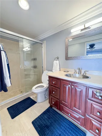 a bathroom with a sink vanity granite toilet and a shower