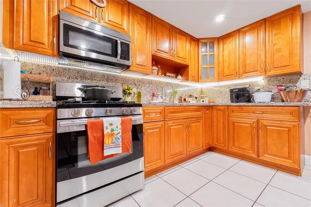 a kitchen with stainless steel appliances granite countertop wooden cabinets a sink and a stove
