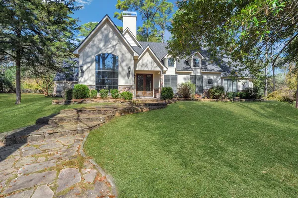 a front view of a house with a yard and trees