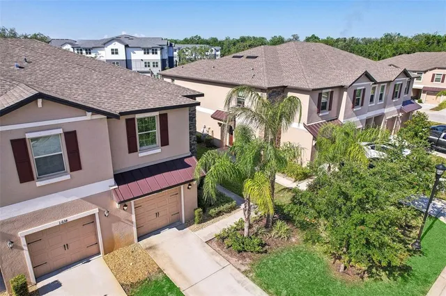 an aerial view of multiple houses with a yard