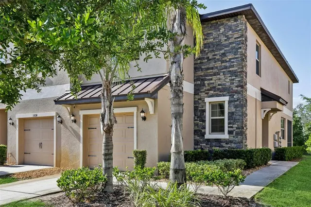 a front view of a house with a garden