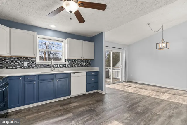 a kitchen with a refrigerator cabinets and wooden floor