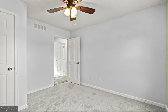 an empty room with a chandelier fan and a chandelier fan