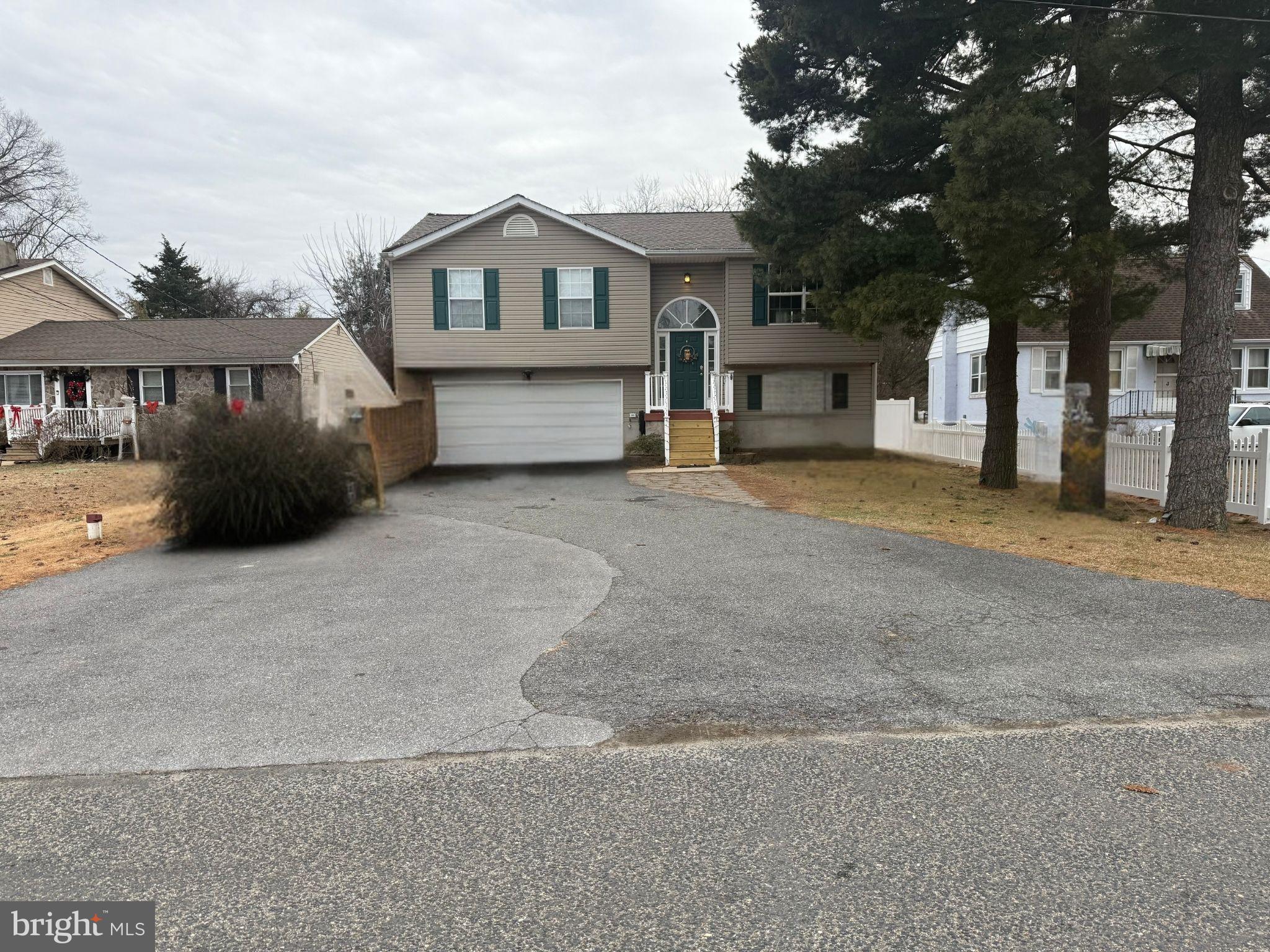 1821 Division Road Pasadena, MD 21122 - Photo 2 of 5 a front view of a house with a garden and trees