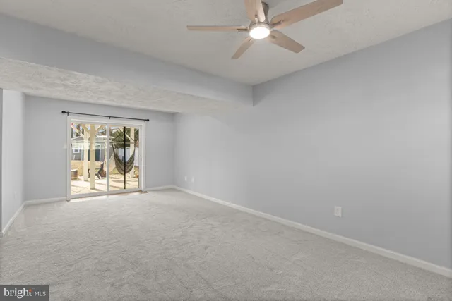 an empty room with a ceiling fan and a window