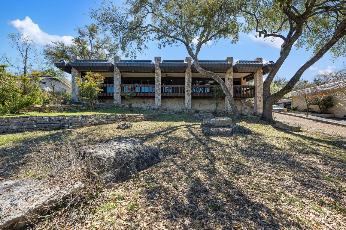 a view of a house with a yard and large trees